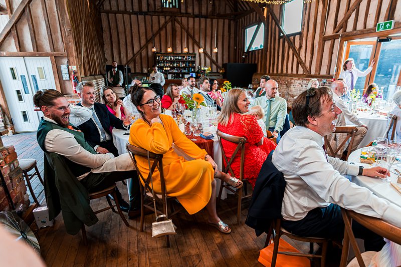Guests laughing at a barn wedding reception.
