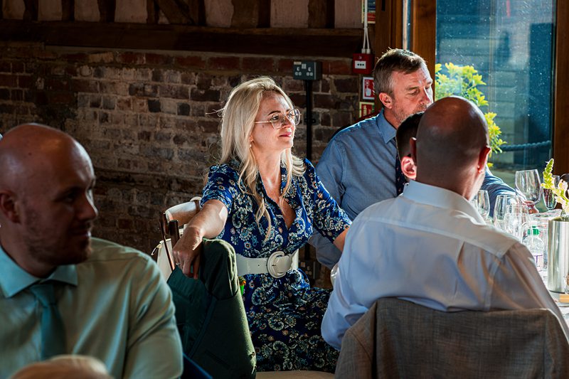 Group dining at rustic venue with sunlight.