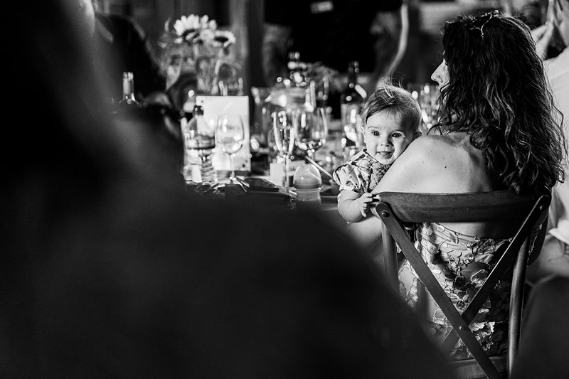 Woman holding baby at a dining table