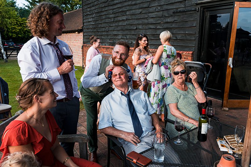 Group enjoying outdoor event with drinks and laughter.