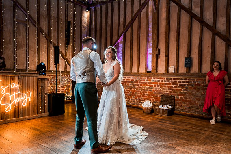 Couple dancing in decorated barn wedding venue.