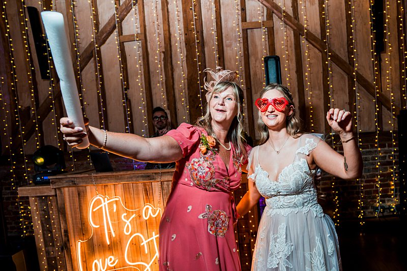 Women smiling in wedding-themed party setting.
