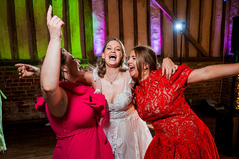 Three women celebrating at a wedding party.