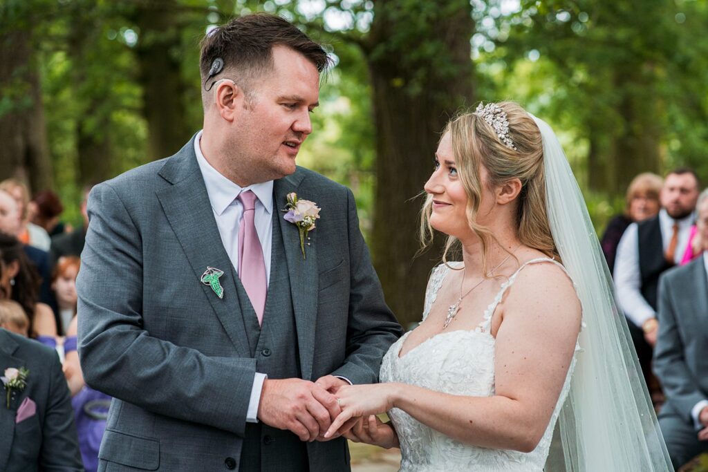 Bride and groom exchanging vows outdoors.