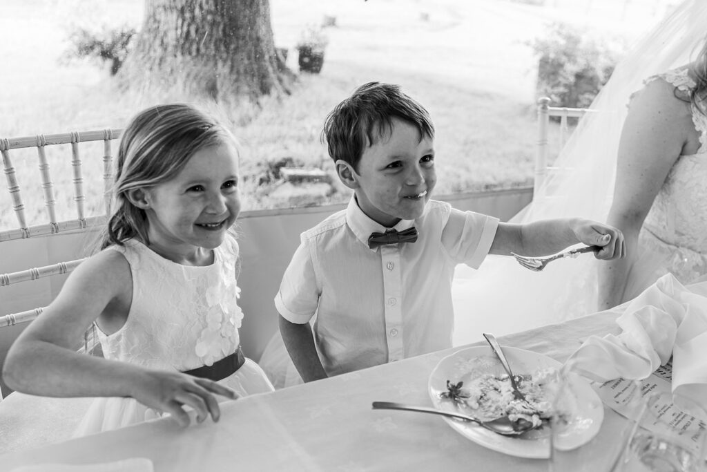 Smiling children at a wedding reception table.