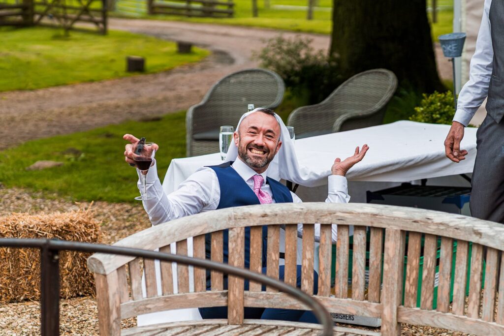 Man celebrating with wine outdoors at an event.