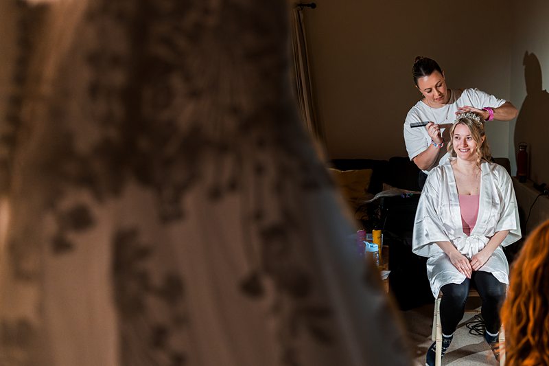 Hairdresser styling hair before wedding ceremony.