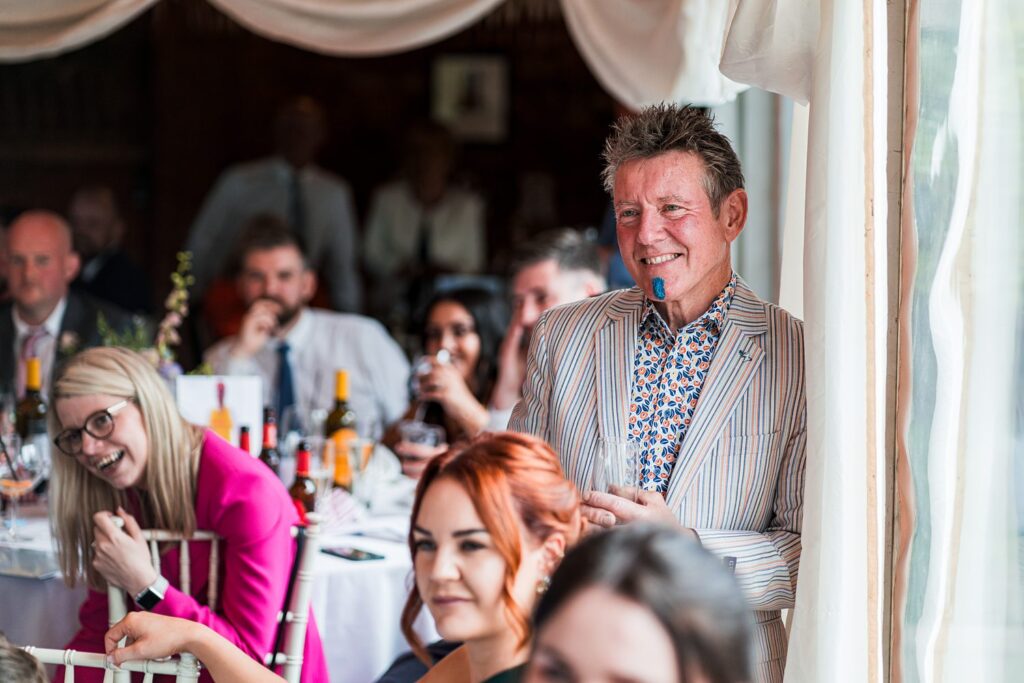 Smiling guests enjoying a lively wedding reception.