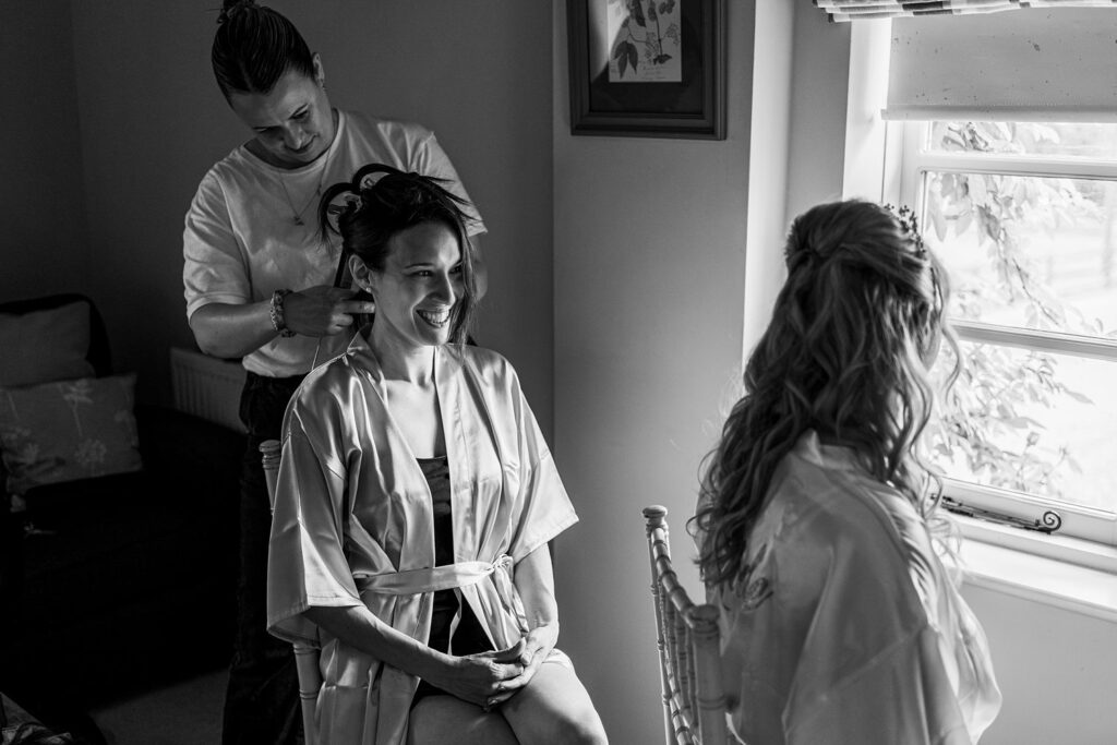 Hairdresser styling bride's hair for wedding.