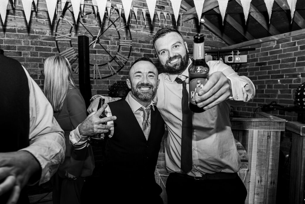 Two men celebrating with drinks at a party.