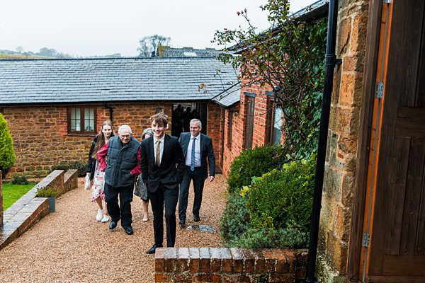 Group walking up path by brick building