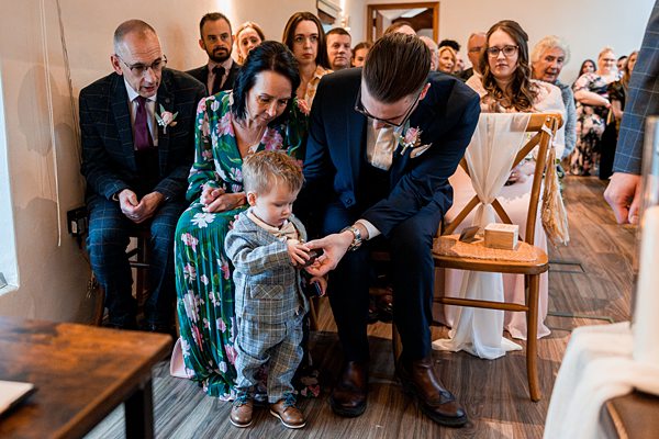 Wedding guests seated, child interacts with adults.