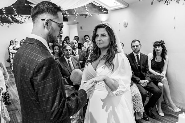 Bride and groom exchanging rings at ceremony.