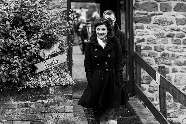 Smiling woman arriving at stone building reception