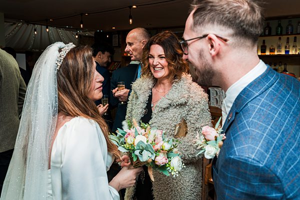 Bride greeting guests at wedding reception.