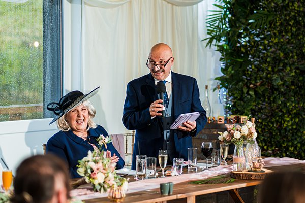 Man giving speech at wedding reception.