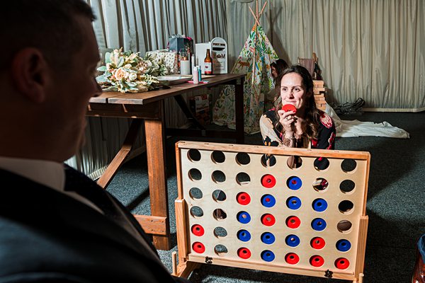 Woman playing giant Connect Four at wedding reception.