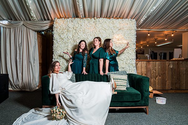 Women pose against floral backdrop at event