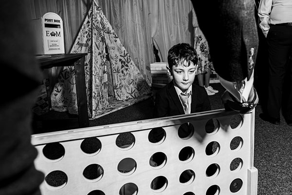 Boy plays giant connect four at a party.