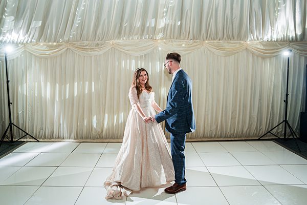 Couple dancing on a decorated wedding dance floor.