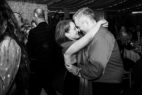 Couple dancing at a lively wedding reception.