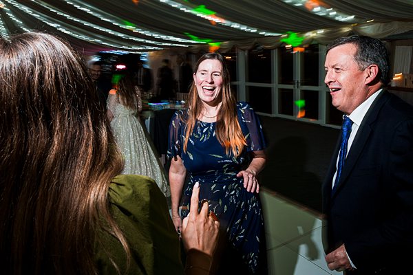 Guests laughing and dancing at a party.
