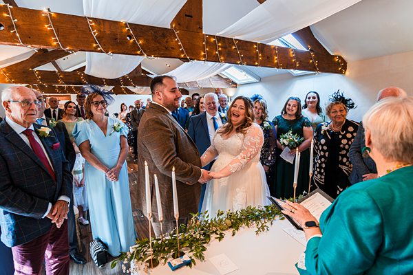 Couple exchanging vows at festive wedding ceremony.