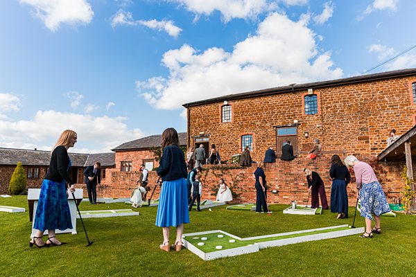 Outdoor mini-golf game at rustic venue
