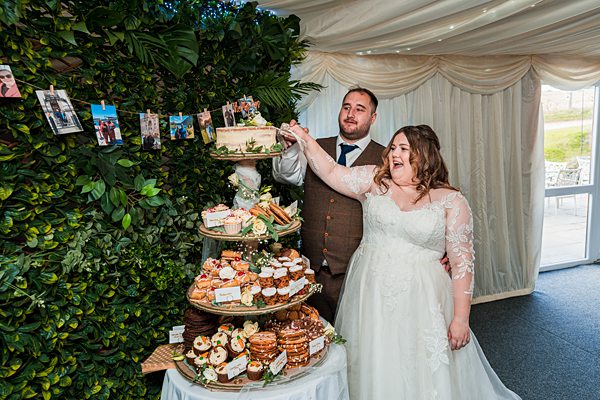 Bride and groom cutting wedding cake.