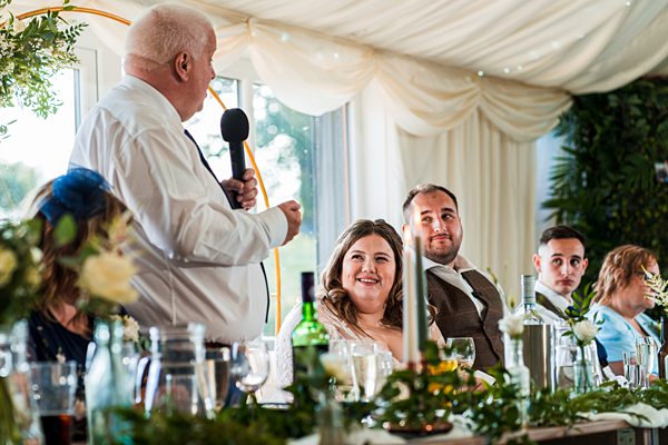 Wedding speech during reception dinner with guests listening.