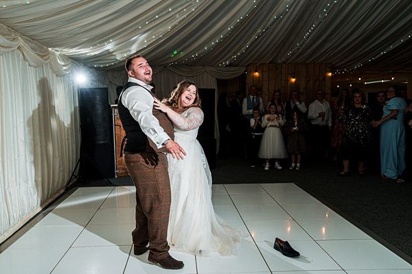 Bride and groom smiling during first dance at wedding.