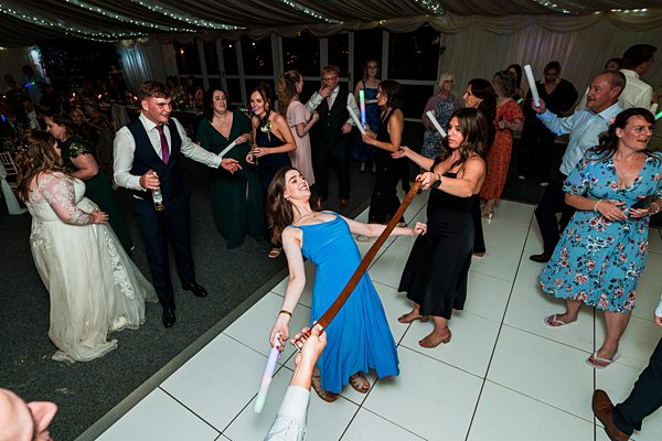 Guests limbo dancing at wedding reception party.