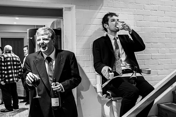 Men laughing and drinking at a formal event