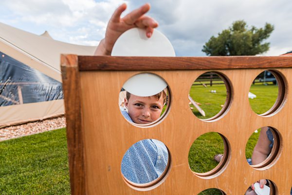 Boy playing giant connect four outdoors