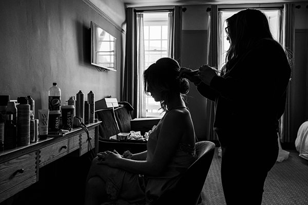Silhouette of woman doing bride's hair preparation