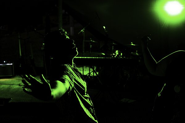 Person dancing under green stage lights.
