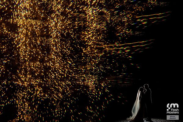 Bride and groom with dramatic fireworks display.