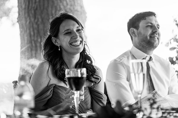 Smiling couple enjoying drinks at outdoor event.