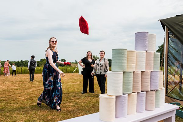 Woman playing outdoor tin can game at event.