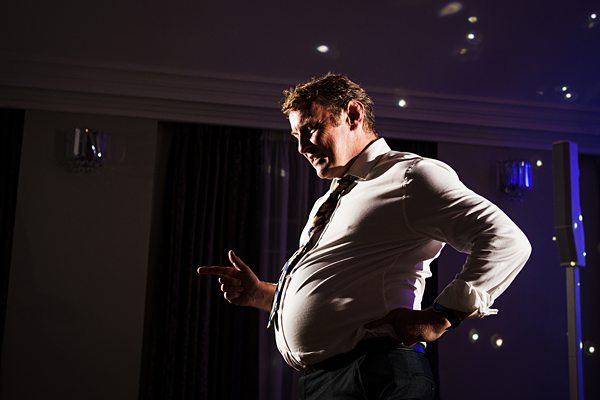 Man posing dramatically in dim lighting.