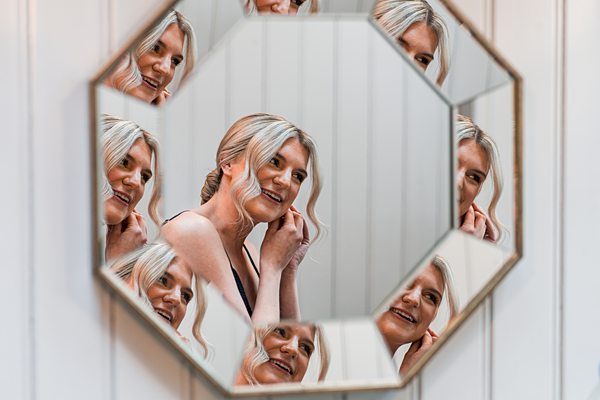 Woman reflected multiple times in octagonal mirror.
