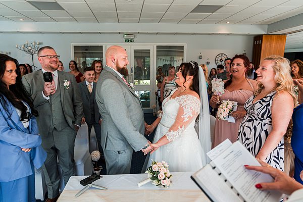 Bride and groom smiling during wedding ceremony.