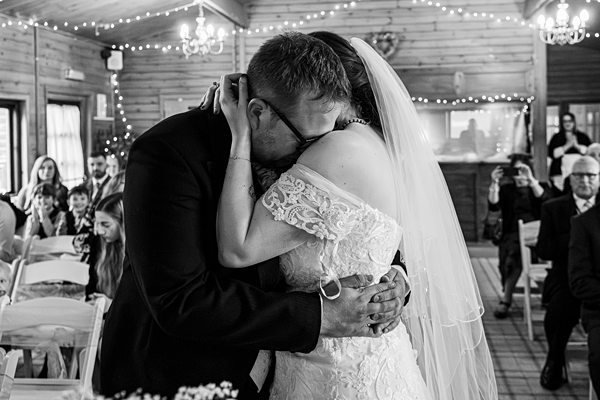 Bride and groom embrace during wedding ceremony.