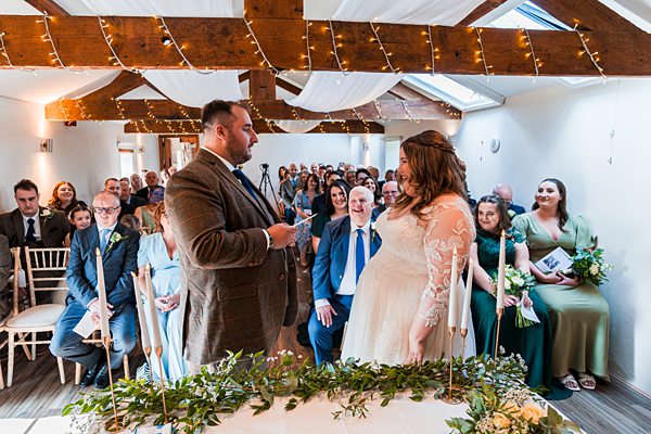 Wedding ceremony with couple exchanging vows, decorated venue.