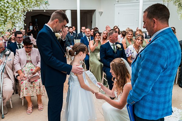 Wedding ceremony with bride, groom, and young girl.
