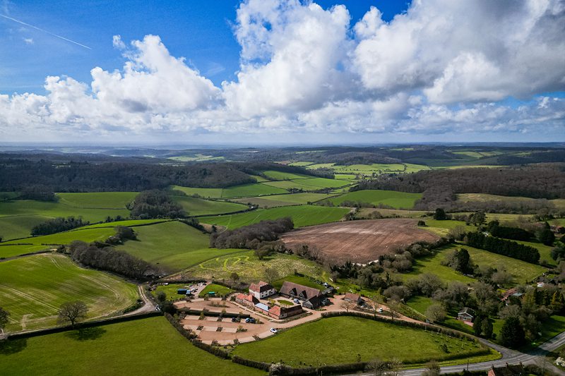 Aerial view of countryside landscape with farm buildings.