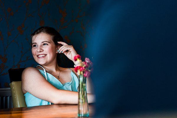 Smiling woman with flowers on table indoors