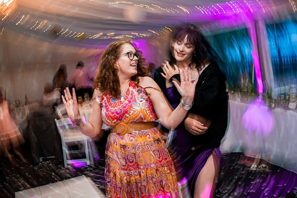 Two women dancing at a colourful party.