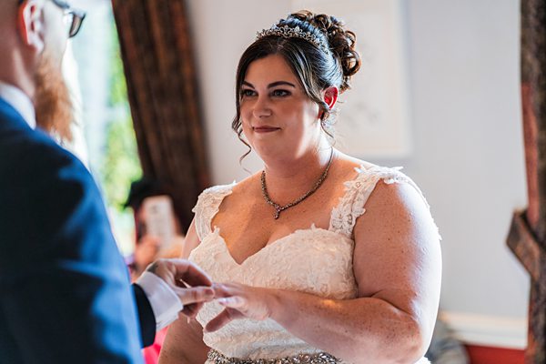 Bride exchanges rings during wedding ceremony.