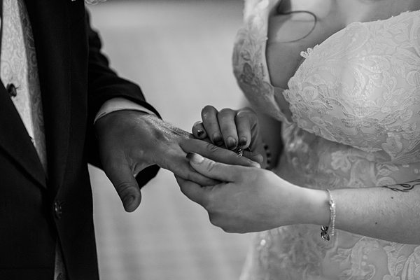 Bride and groom exchanging rings during wedding ceremony.